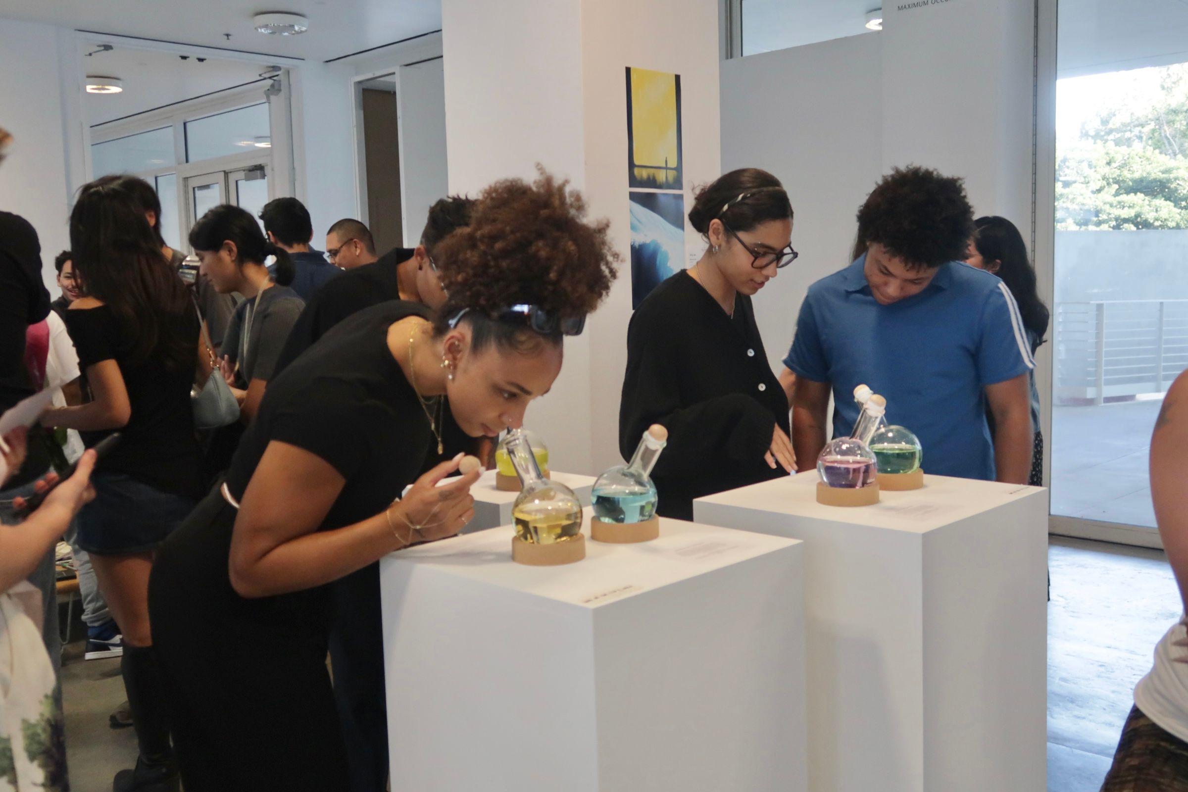 A person leans over a vial to smell its contents.