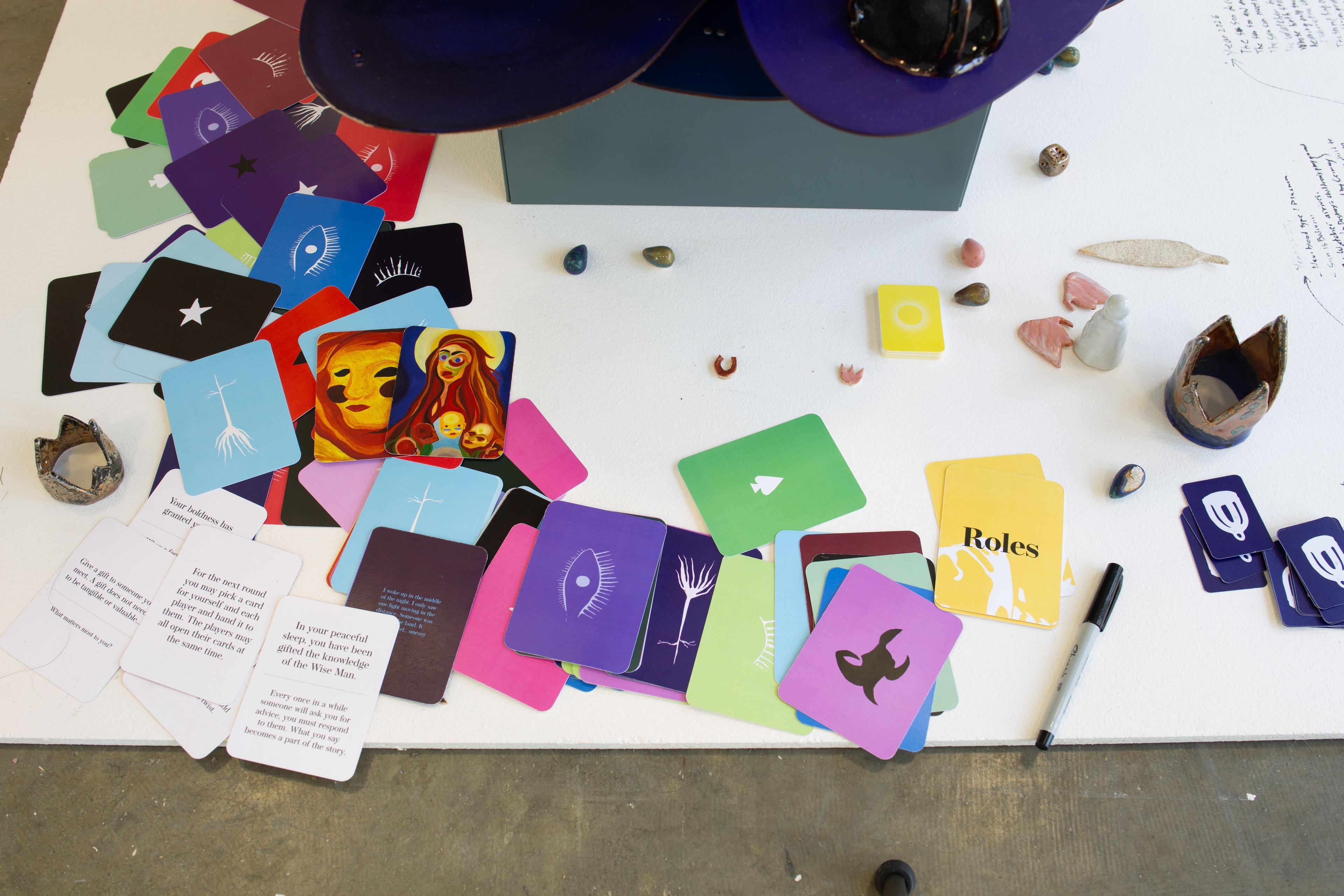 A close up of the game cards and crown-shaped game pieces scattered around the base of the tower.